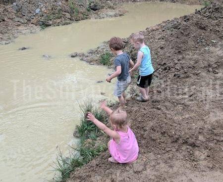 children playing in muddy creek