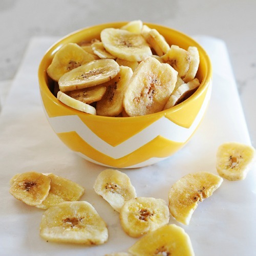 banana chips in a yellow bowl after dehydrating bananas