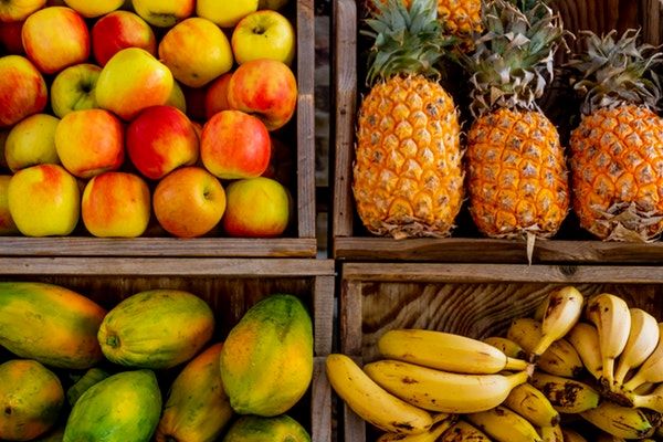 apples, bananas, pineapples and papaya display  - thrive life