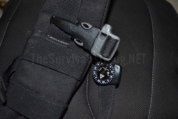 button compass attached to a backpack