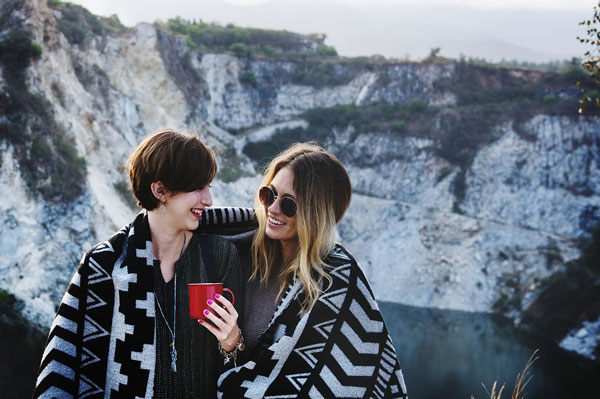 the two women sharing the stripe blanket in the mountain