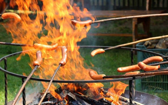 sausages on sticks on open flame