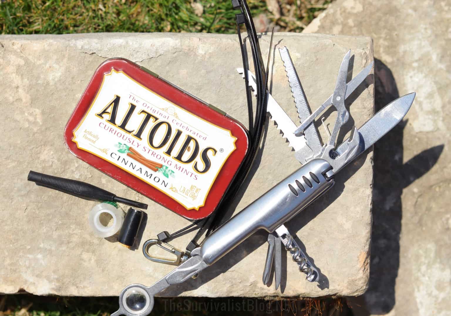 multi-tool mini screwdriver next to Altoids kit