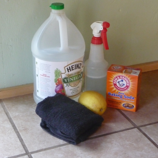 vinegar in a bottle, baking soda, lemon and towel