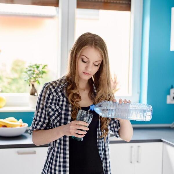 a woman pouring water into a glass