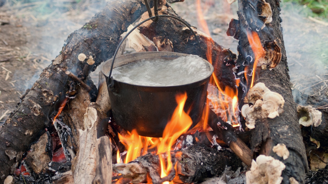 Water boiling in a pot on firewood