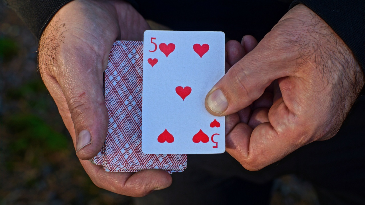 man holding cards in street game