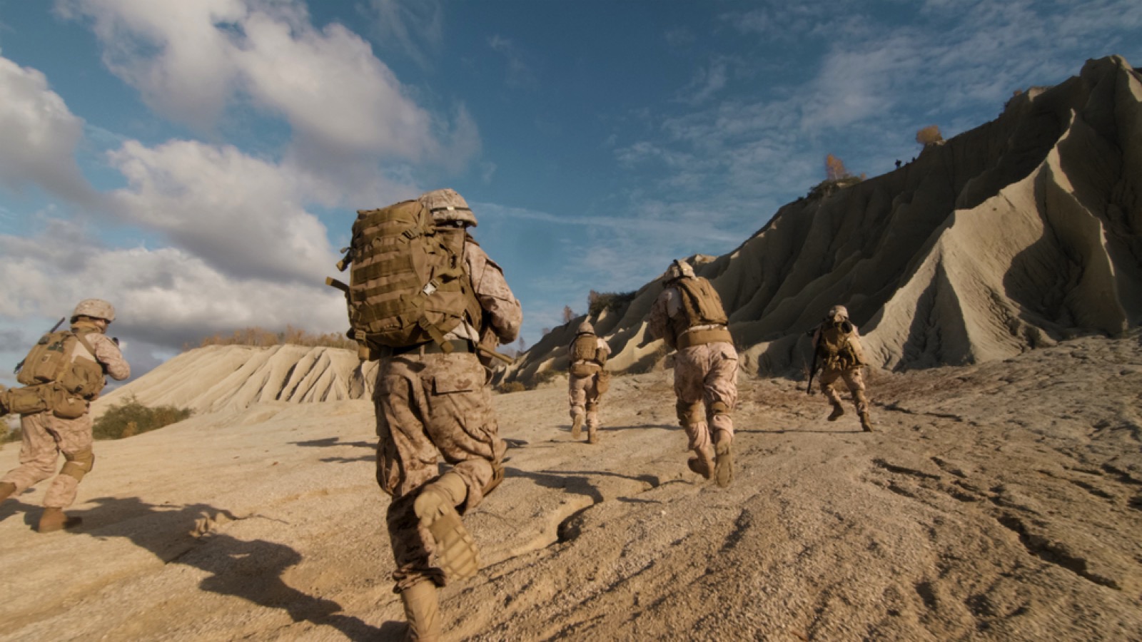 Military men running in desert