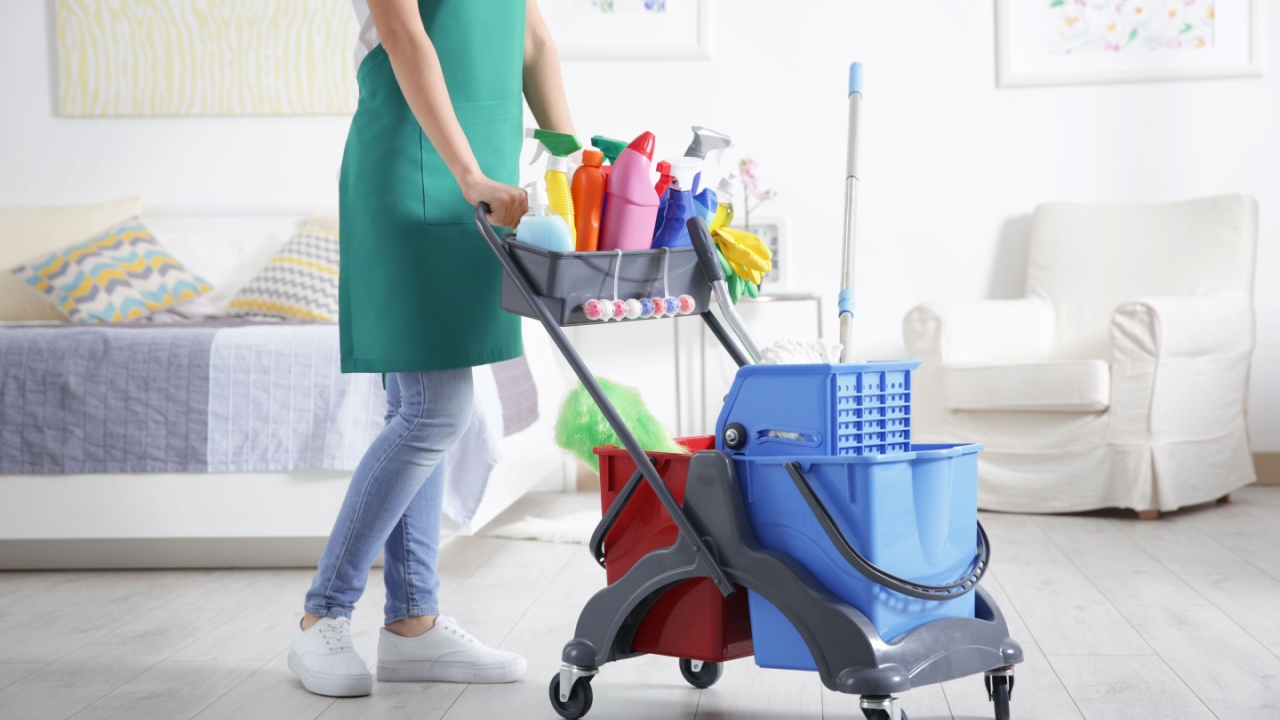 Lady pushing a cleaning cart full of supplies, hygiene