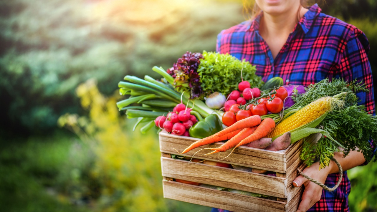 woman carrying all her home grown vegetables