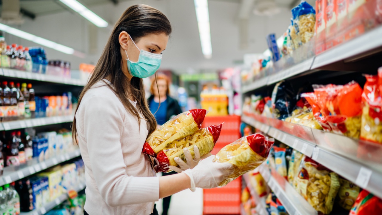 Buyer wearing a protective mask. Shopping during the pandemic quarantine. pantry groceries, preparation. Budget pastas and noodles. bulk buy