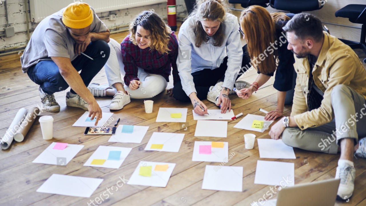 Young creative coworkers making project organizing tasks and processes writing notes on stickers, crew of designers collaborating in office researching and planning strategy for future project,