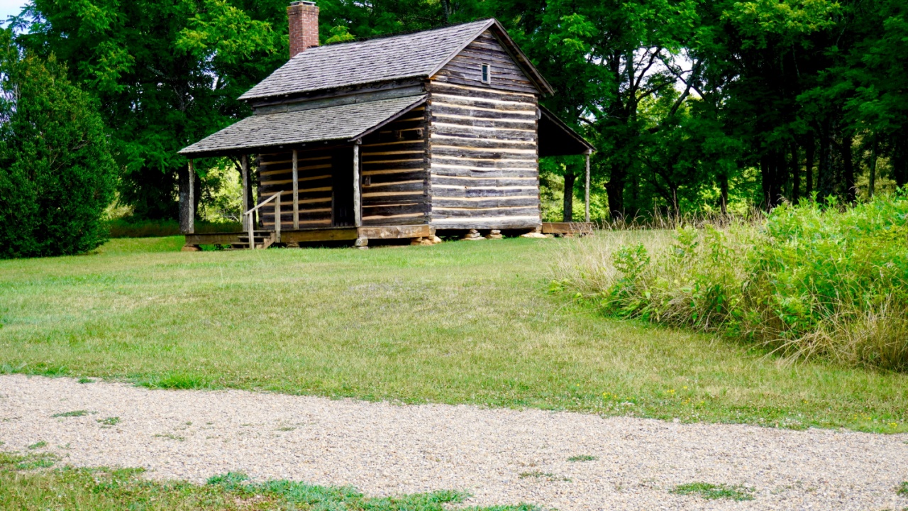 log cabin stands as a typical backcountry homestead of the time.