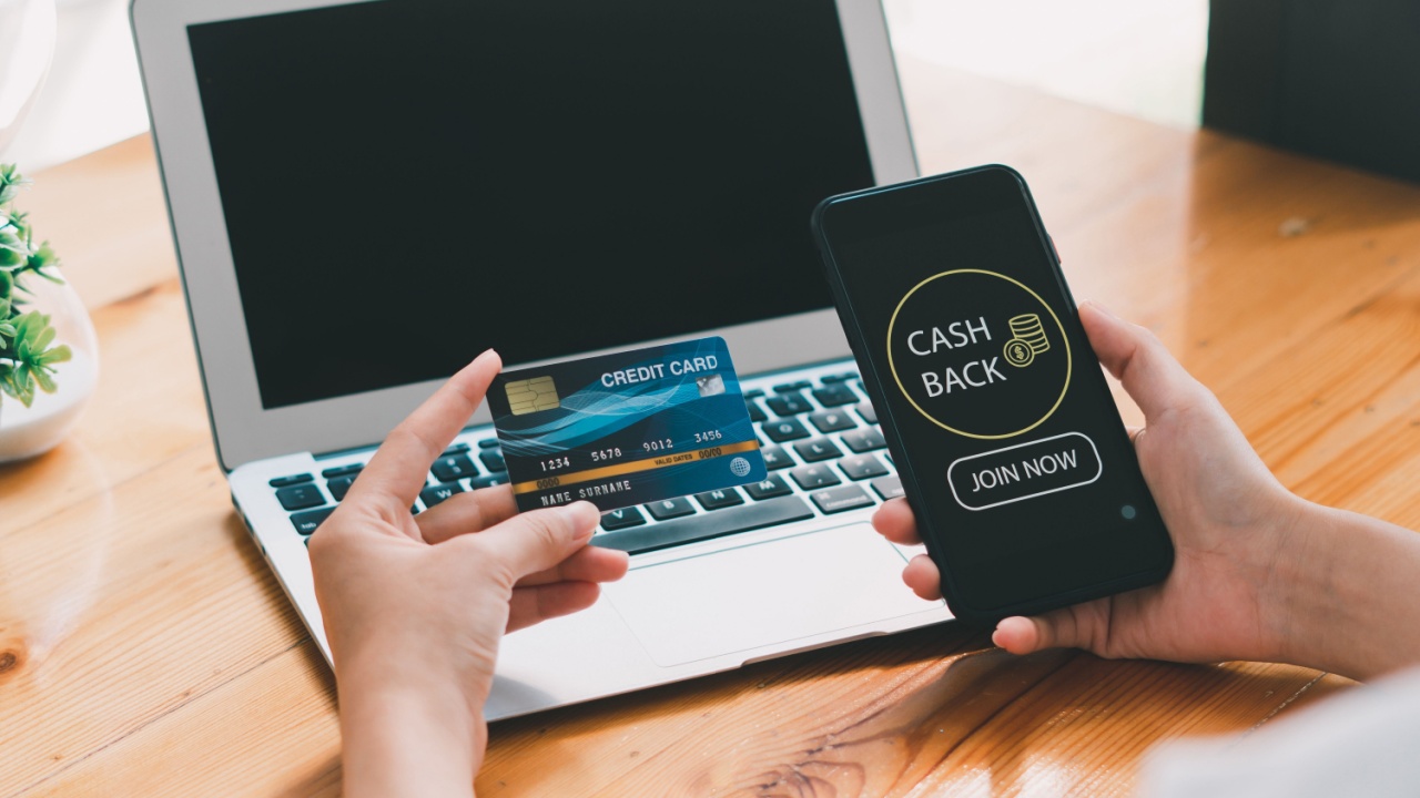 Woman taking benefit of cash back using smart phone, shopping and money refund concept. Close up hand holding smartphone with button to get started the cashback.