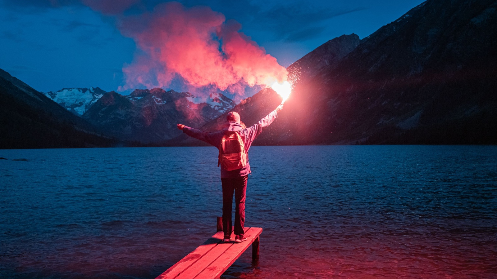 The hiker on the pier lit the emergency red torch and calling for help. Rescue flare and sos signal