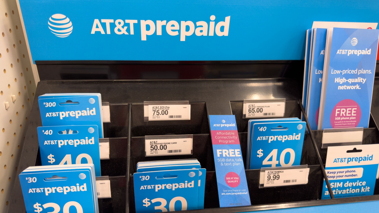 eSim and ATT Prepaid phone cards on display stand inside a department store.