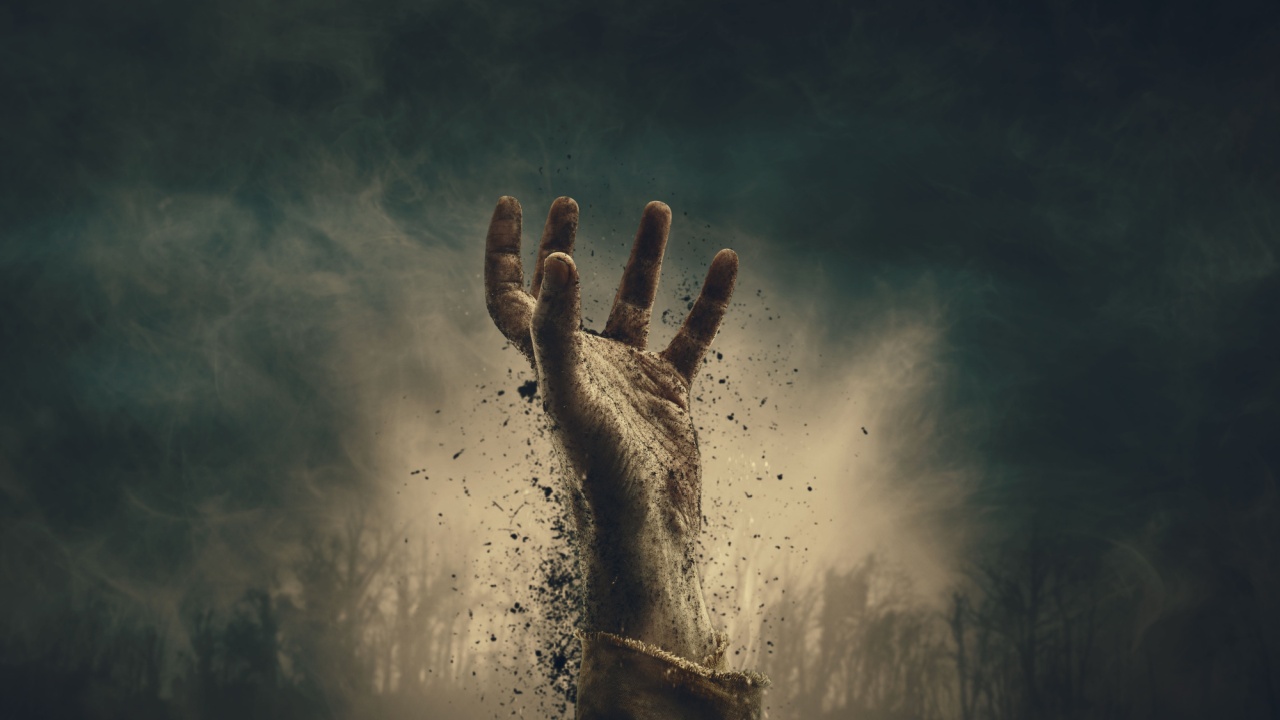 Creepy dirty zombie hand rising in the night sky surrounded by fog, horror