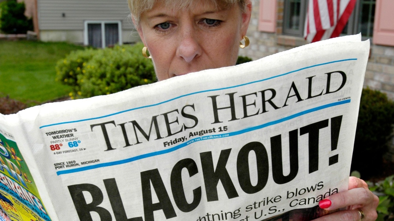 Adult reads about Black Out of electrical power during the failure of a power grid over the eastern part of the United States.
