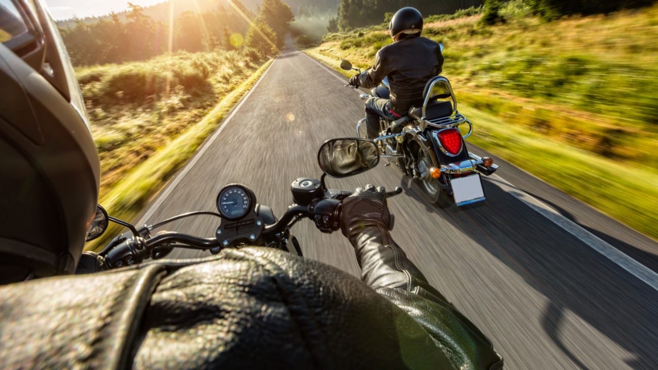 Two motorbikers riding on empty road with sunrise light,