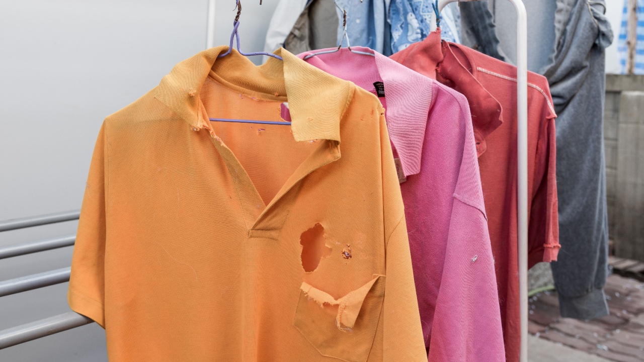 Old Colorful clothes with old hangers , second hand shirts look like rag cloth