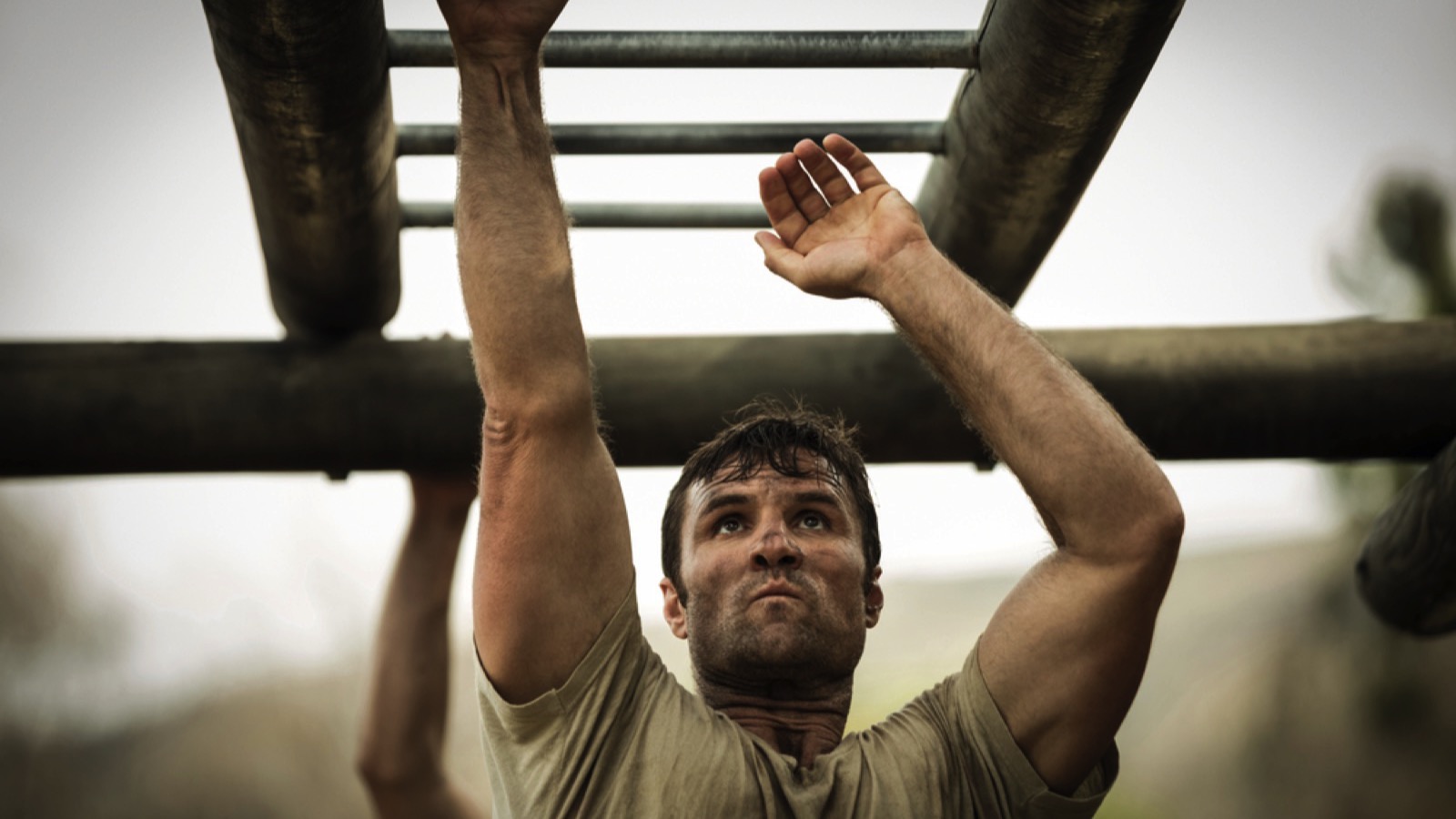 Soldier climbing monkey bars in boot camp