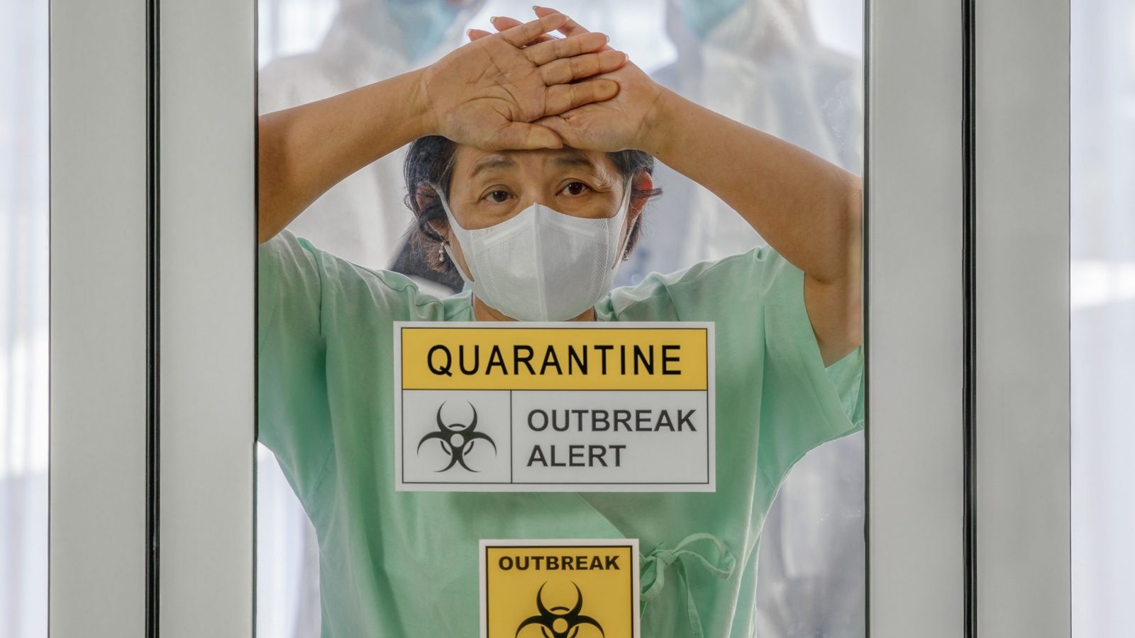 nfected patient in quarantine room with quarantine and outbreak alert sign at hospital with blurred disease control experts, coronavirus outbreak control