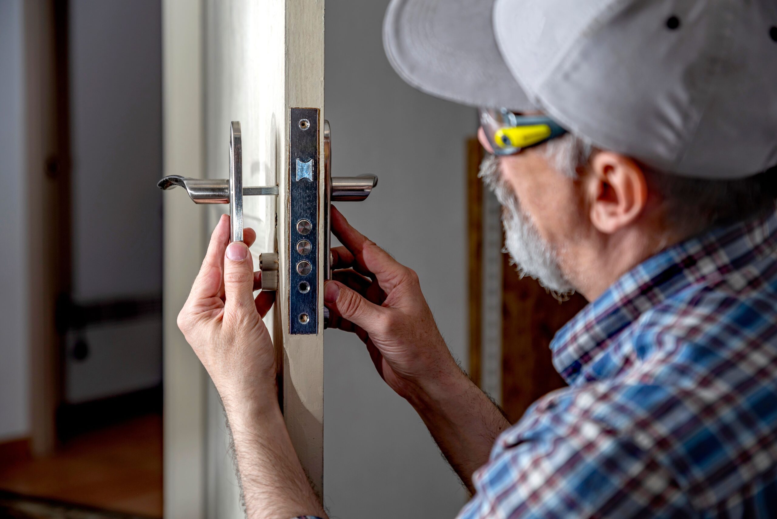  locksmith working with open white door indoor.