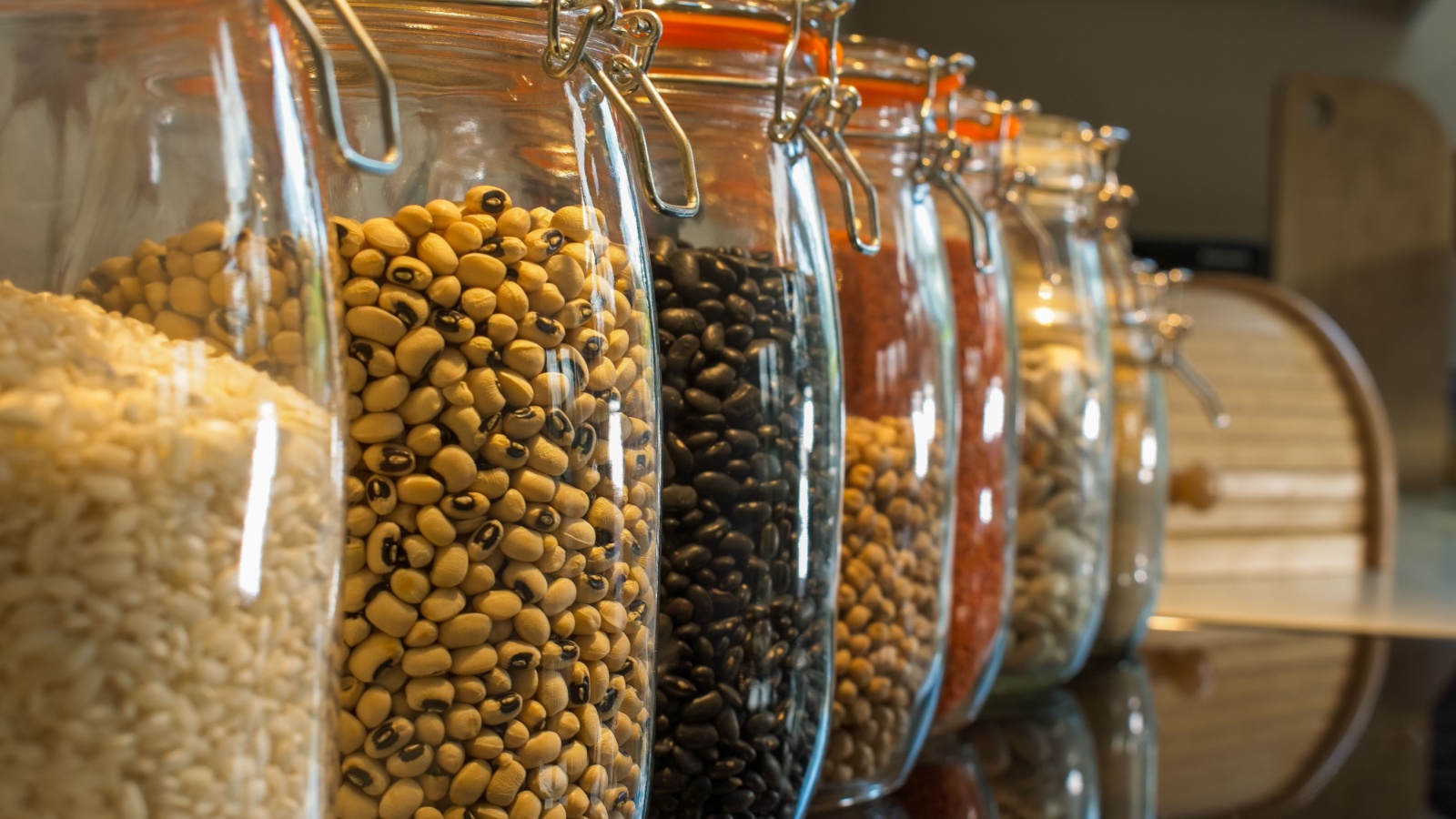 Beans and lentils placed in jars. Colourful selections of peas, a cooks essential store cupboard ingredients.