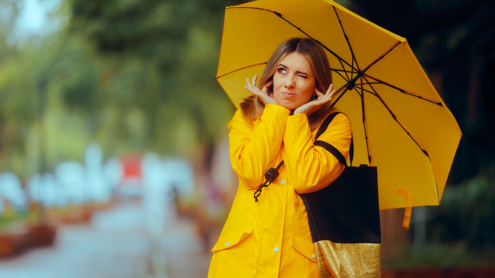 Woman Covering her Ears Hearing a Loud Thunder during Storm. Stressed adult walking through the rain on a stormy day