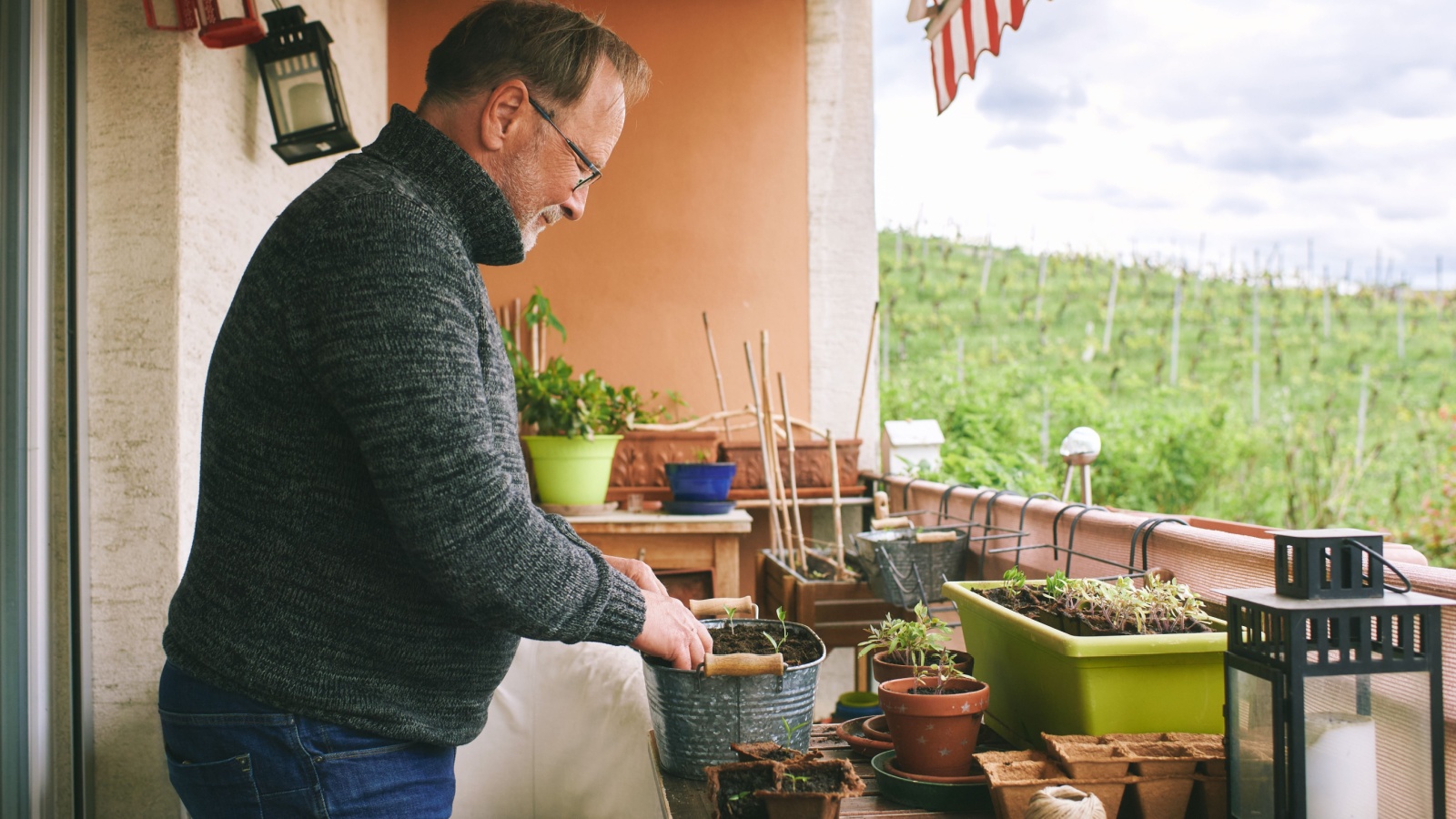 man planting seeds on his apartment balcony, prepper,
