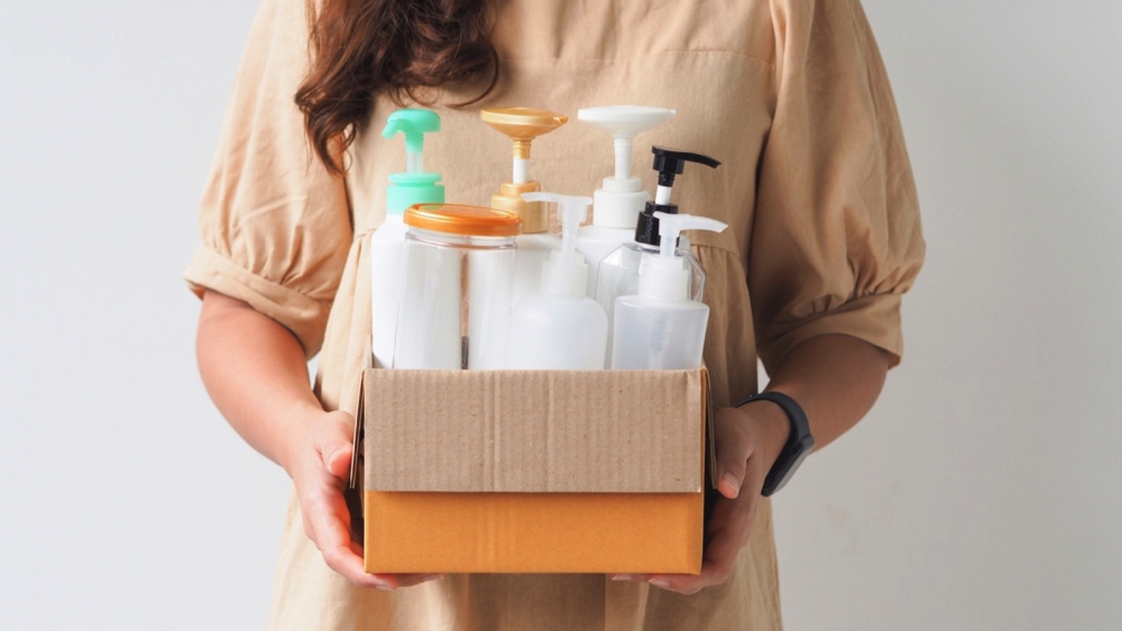 Woman hand holding box of plastic bottles and jar