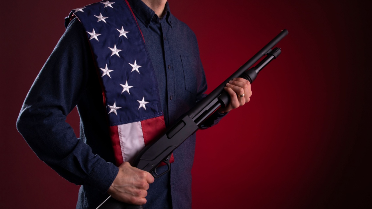 man with American Flag and shotgun