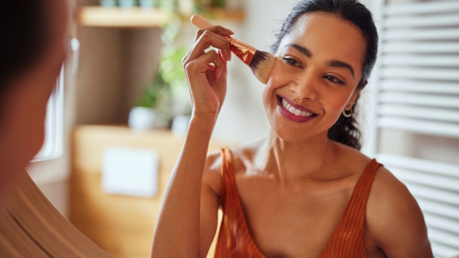 Happy woman doing makeup