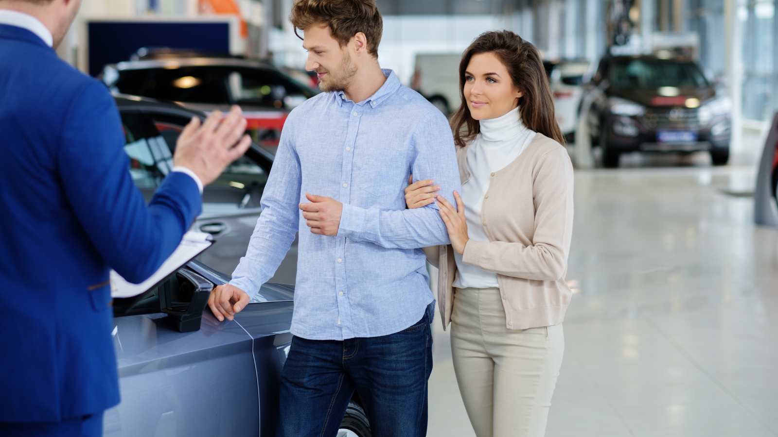 Couples looking at car in showroom