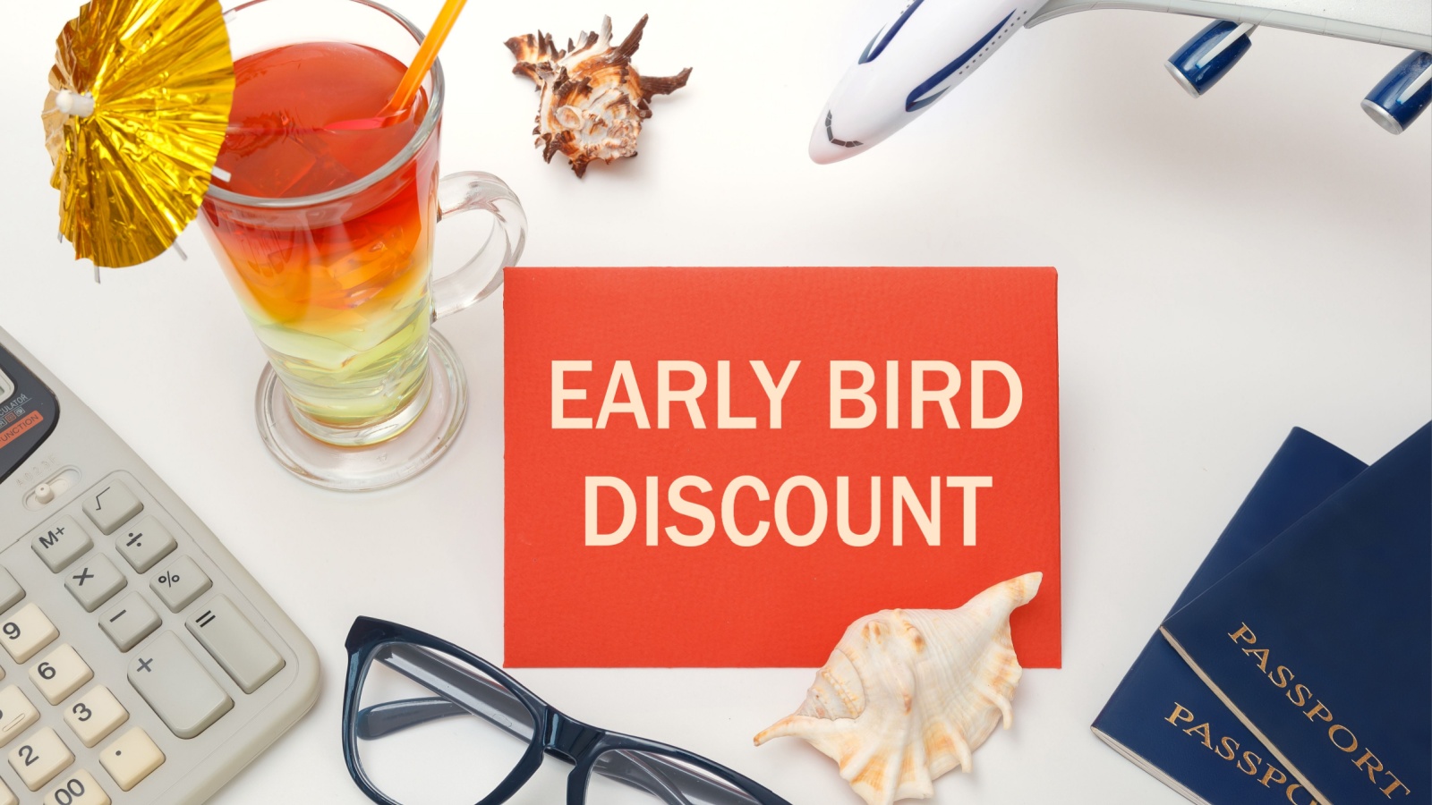 Early bird discount - the inscription on the notebook, cocktails, plane, documents. Travel concept.