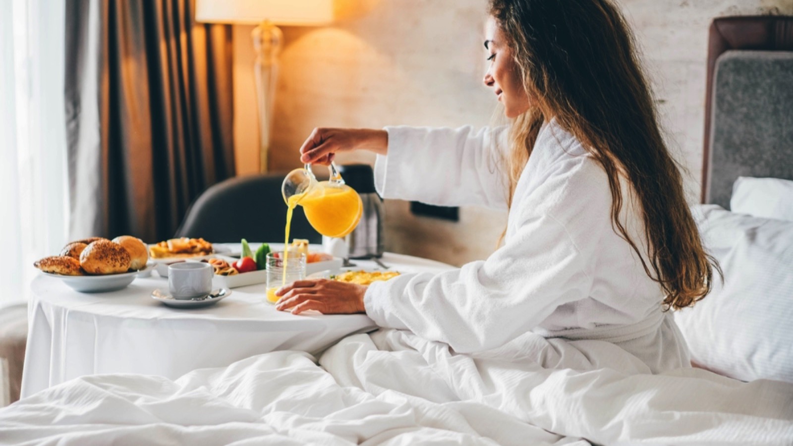 WOman in hotel room eating breakfast