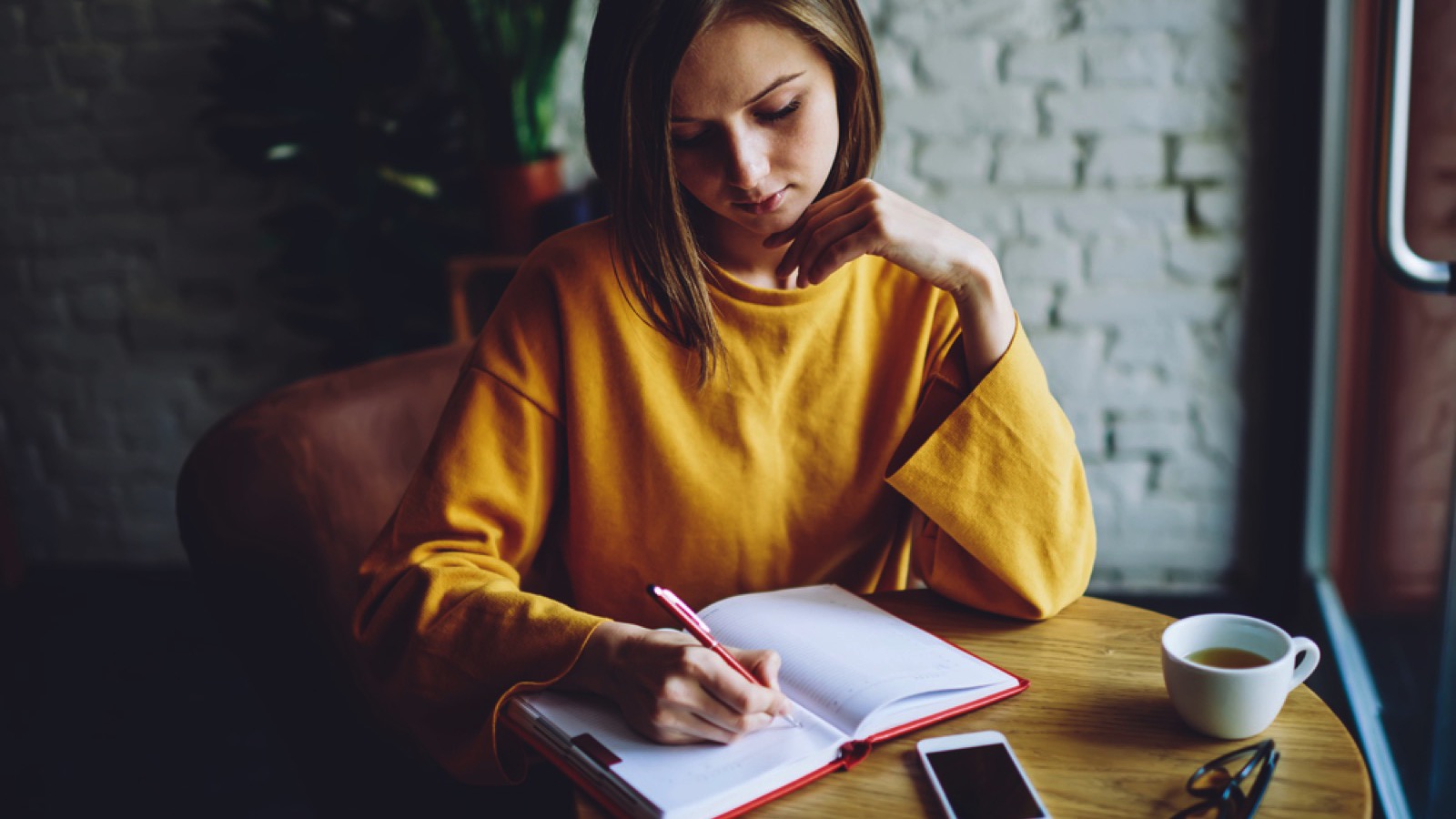 Woman writing in spending journal